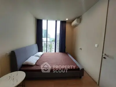 Modern bedroom with large window and city view, featuring a comfortable bed and air conditioning.
