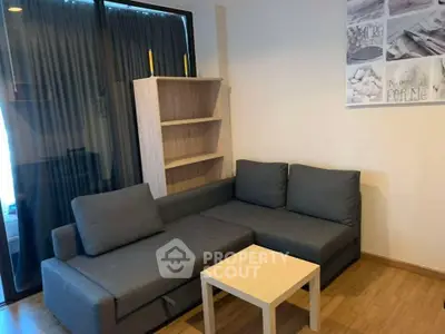 Modern living room with sleek gray sofa and wooden flooring, perfect for cozy relaxation.