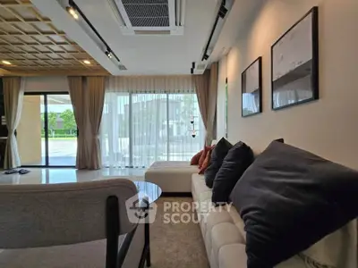 Luxurious modern living room with elegant decor and large windows offering a serene view.