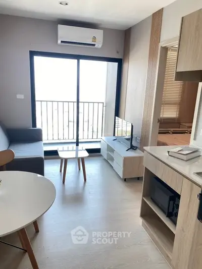 Modern living room with balcony view, sleek furniture, and natural light in a stylish apartment.