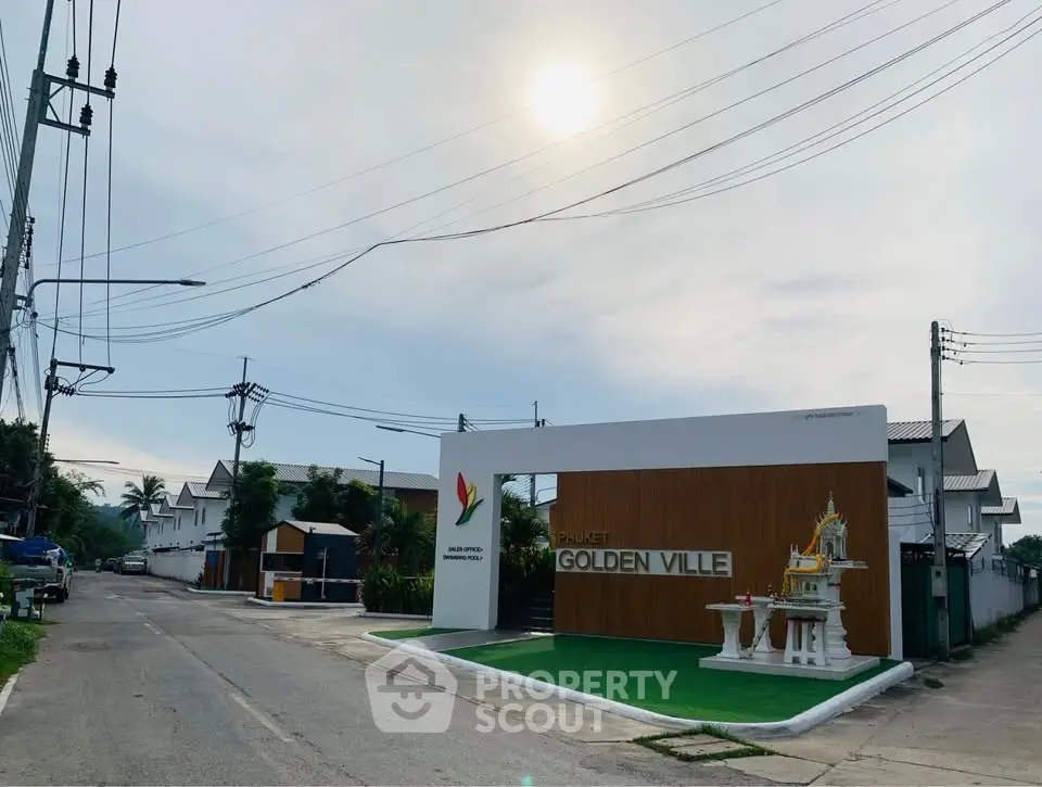 Charming entrance of Phuket Golden Ville with serene street view and clear skies.