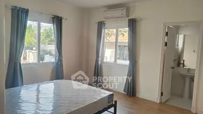 Spacious bedroom with natural light and en-suite bathroom in modern home