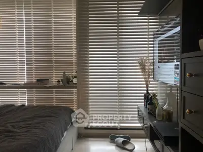 Cozy bedroom with modern blinds and sleek decor, perfect for relaxation and comfort.