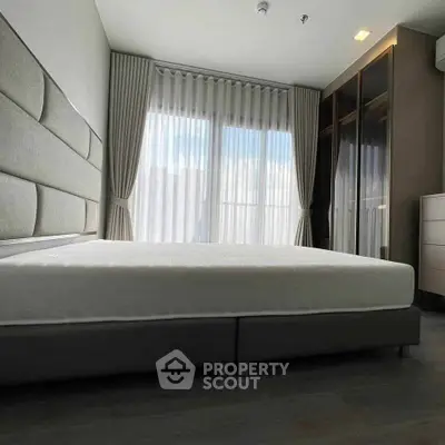 Spacious bedroom with modern design and large windows for natural light.