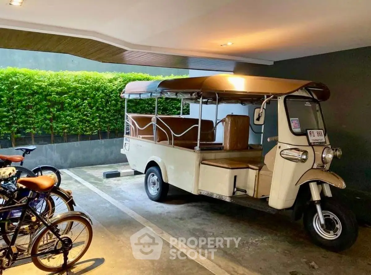 Covered parking area with tuk-tuk and bicycles, showcasing unique transportation amenities.