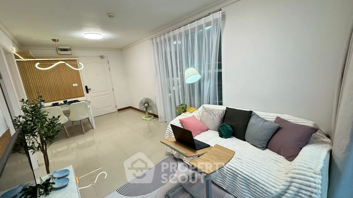 Modern living room with cozy sofa, stylish decor, and dining area in open layout apartment.