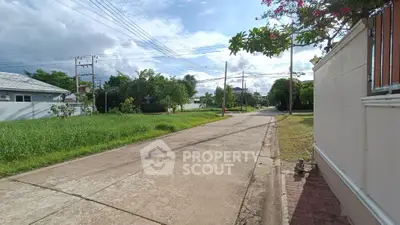 Charming suburban street view with lush greenery and clear skies, perfect for tranquil living.