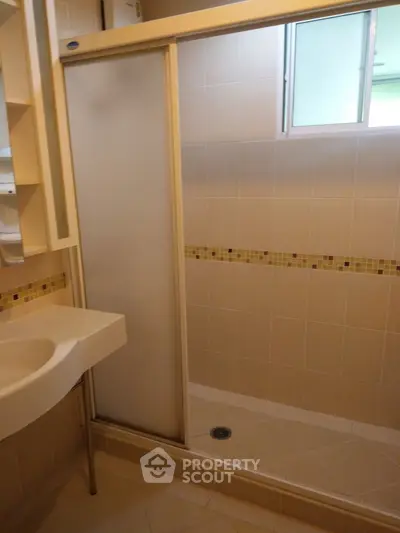 Modern bathroom with frosted glass shower door and stylish tile accents.