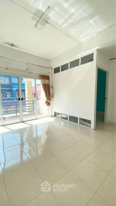 Bright empty room with large windows and balcony access, perfect for customization.