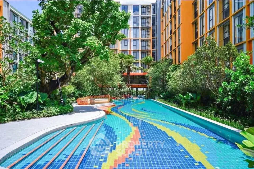 Vibrant apartment complex with colorful pool and lush greenery, perfect for modern urban living.
