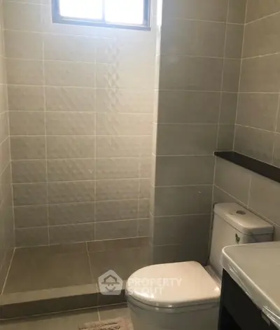 Modern bathroom with sleek tiles and natural light from window