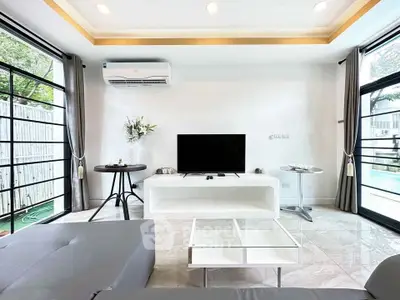 Modern living room with sleek design, large windows, and pool view, perfect for relaxation and entertainment.