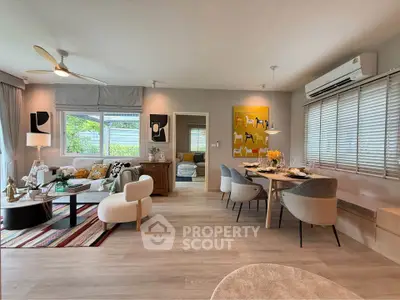 Spacious modern living room with dining area, stylish decor, and large windows for natural light.