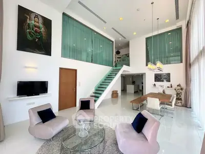 Luxurious modern living room with high ceilings and elegant decor in a spacious duplex apartment.