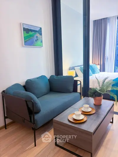 Modern living room with cozy sofa and stylish decor adjacent to a bright bedroom.
