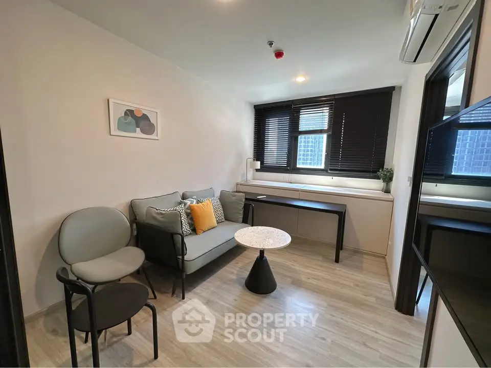 Modern living room with stylish decor and natural light, featuring a cozy sofa and elegant furnishings.