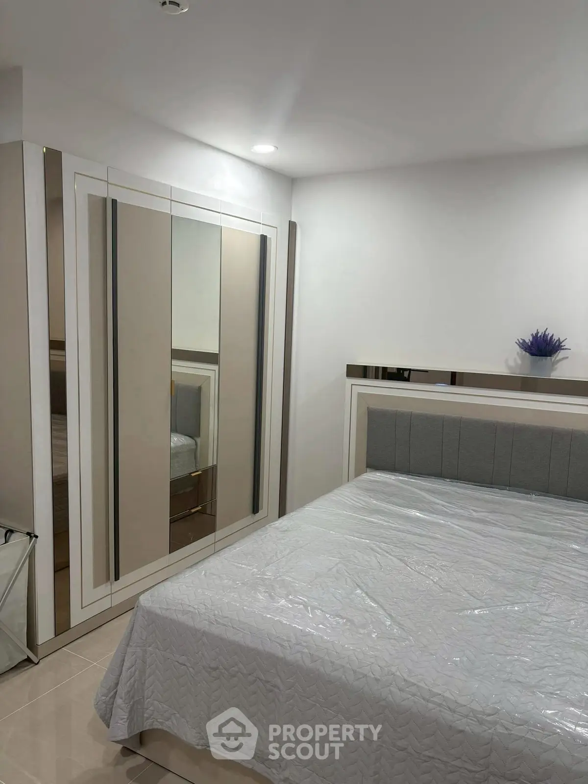 Modern bedroom with sleek wardrobe and stylish bed in a cozy setting.