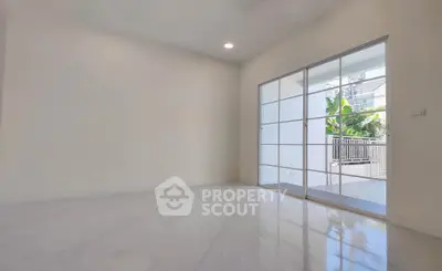 Spacious empty room with sliding glass doors leading to a balcony, perfect for customization.