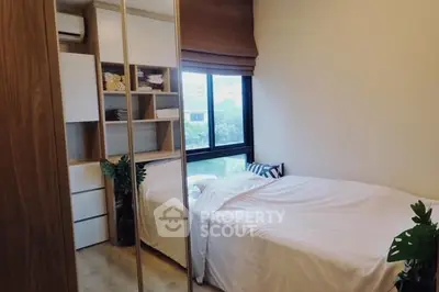 Cozy bedroom with large window and built-in storage, perfect for modern living.