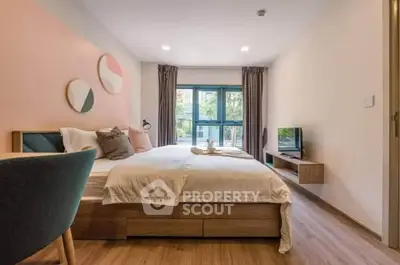 Modern bedroom with stylish decor and large window offering natural light.