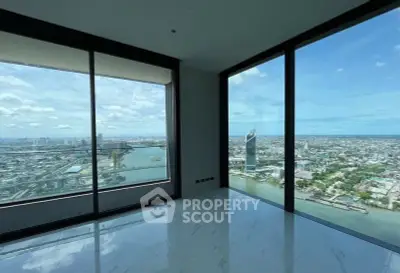 Stunning high-rise apartment with panoramic city and river views, featuring floor-to-ceiling windows and sleek flooring.