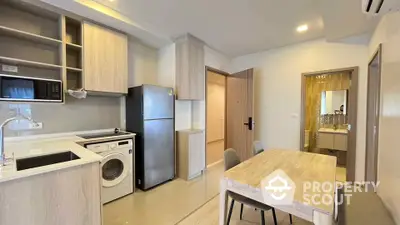 Modern kitchen with washing machine and dining area in sleek apartment