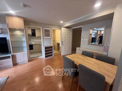 Modern open-plan living and dining area with wooden flooring and stylish furniture.