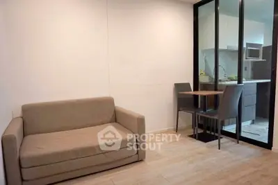 Cozy living room with compact dining area and modern kitchen in open layout apartment.