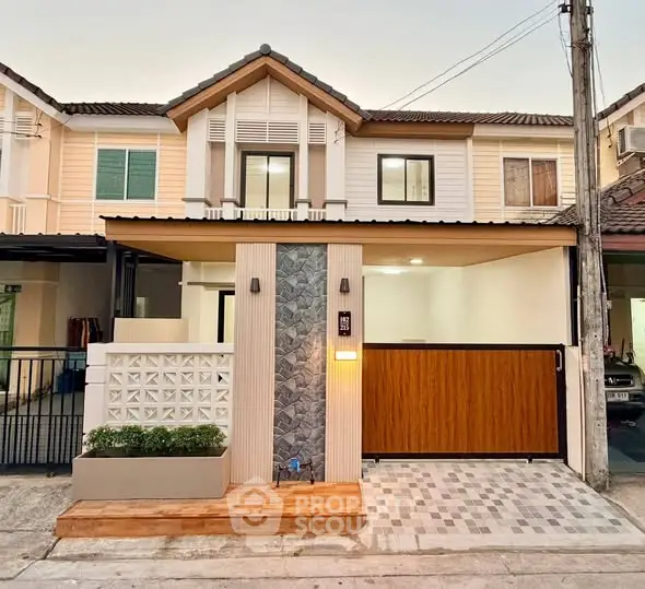 Charming two-story townhouse with modern facade and gated entrance in a serene neighborhood.