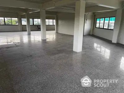 Spacious open-plan commercial space with large windows and polished floors