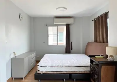 Spacious bedroom with modern decor and natural light in a stylish apartment.