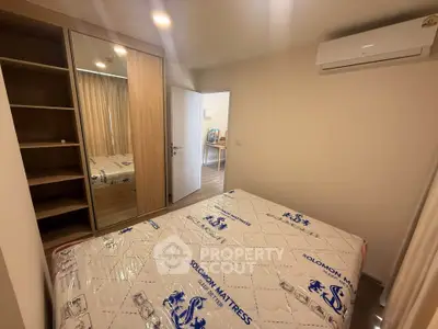 Cozy bedroom with mirrored wardrobe and air conditioning in modern apartment.