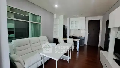 Modern living room with sleek furniture and open kitchen layout in a stylish apartment.