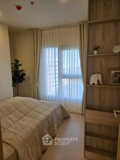 Cozy bedroom with elegant decor and large window for natural light