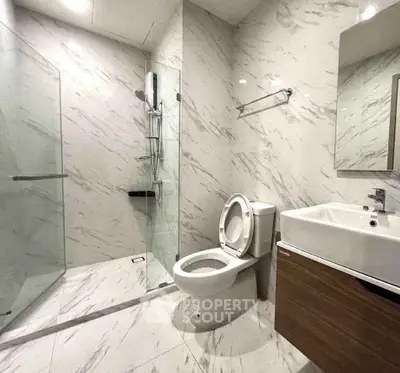 Modern bathroom with marble tiles and glass shower enclosure