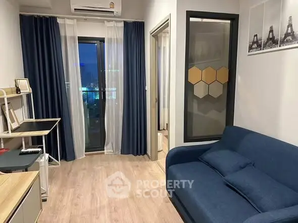 Modern living room with blue sofa and city view from balcony.
