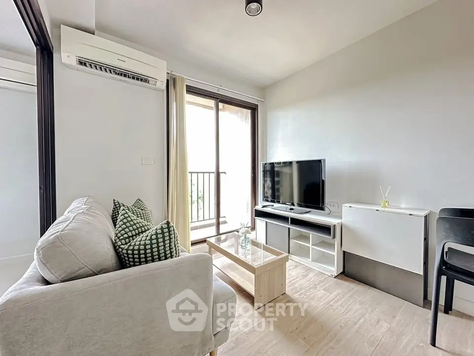 Modern living room with balcony, featuring sleek furniture and natural light.