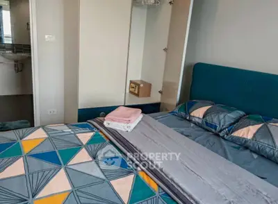 Cozy bedroom with modern geometric bedding and a glimpse of the ensuite bathroom.