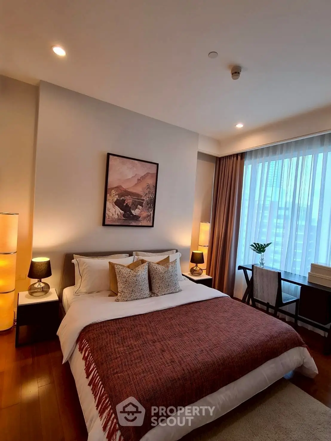 Luxurious bedroom with elegant decor and large window offering city views.