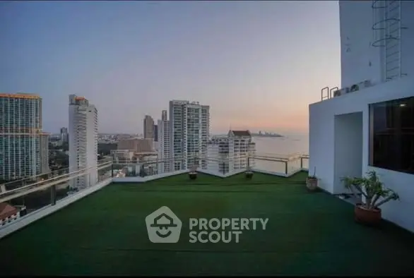Stunning rooftop view with cityscape and ocean horizon at sunset.
