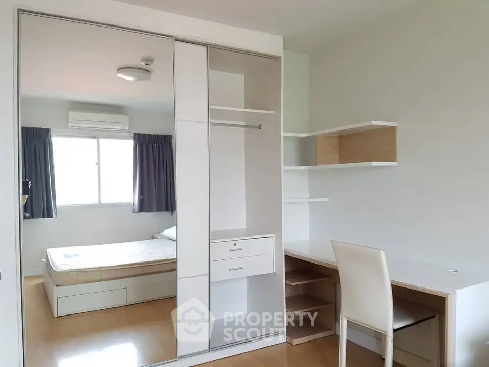 Modern bedroom with built-in wardrobe and study desk, featuring natural light and minimalist design.