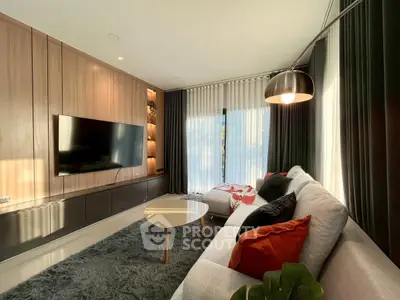 Modern living room with sleek design, large TV, and cozy seating area.