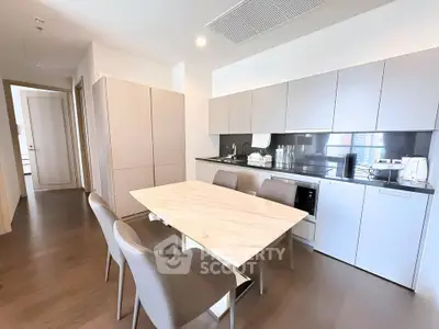Modern kitchen with sleek cabinetry and dining area in a stylish apartment