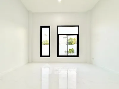 Spacious empty room with large windows and glossy white flooring
