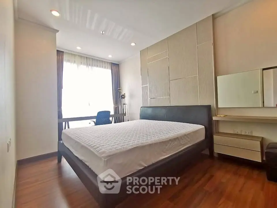Spacious bedroom with modern decor and large window for natural light