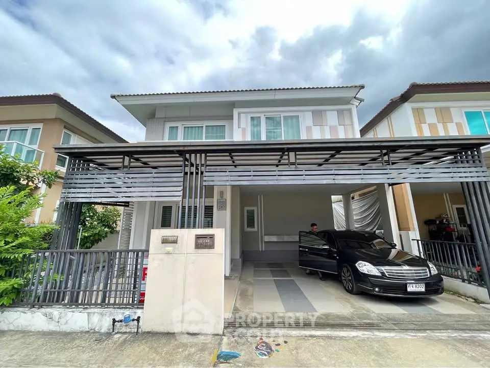 Modern two-story house with carport and sleek design in suburban neighborhood.