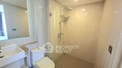 Modern bathroom with glass shower and sleek fixtures in a contemporary apartment.