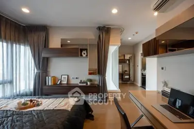 Modern bedroom with stylish decor and workspace, featuring large windows and elegant furnishings.