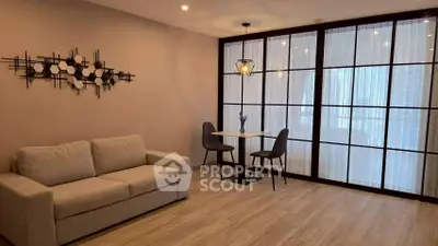 Modern living room with elegant decor and dining area, featuring floor-to-ceiling windows.