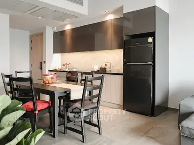 Modern kitchen with sleek cabinets and dining area in stylish apartment.